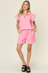 Women's pink Textured, stretchy, and comfy flounce sleeve top and drawstring shorts set. This set is perfect for a travel day, or out running around town, the set can also be dressed up with heels and accessories for versatility while on the go - Reef Love