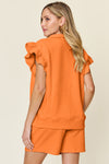 Women's orange Textured, stretchy, and comfy flounce sleeve top and drawstring shorts set. This set is perfect for a travel day, or out running around town, the set can also be dressed up with heels and accessories for versatility while on the go - Reef Love
