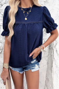 Woman wearing Embroidery Ruffle Sleeve Loose Fit Blouse-Add a touch of charm to your everyday look with this round neck embroidered shirt, featuring ruffle sleeves and a relaxed silhouette and intricate embroidery.