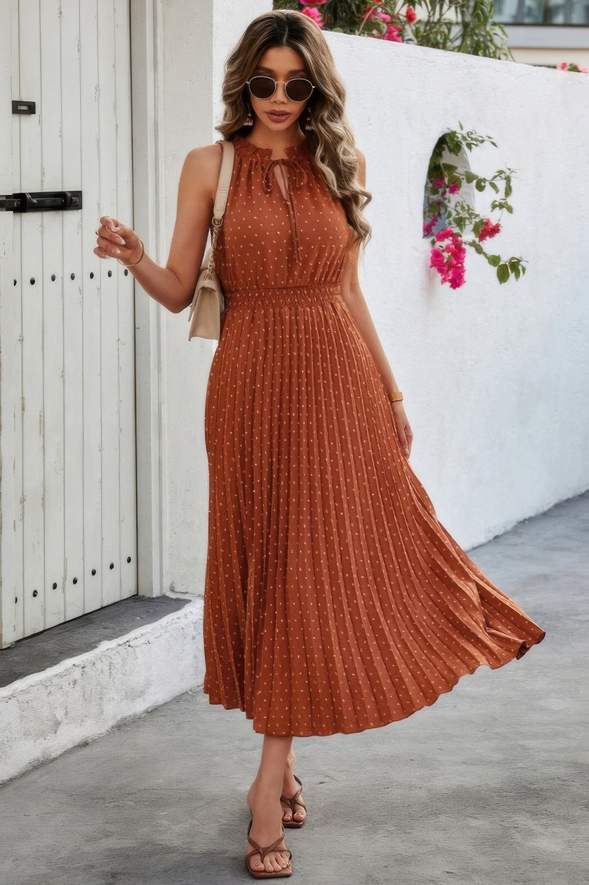 Woman wearing Sleeveless Dot Print Cross Fit Pleated Dress-Step into effortless charm with this Sleeveless Dot Print Cross Fit Pleated Dress. Featuring a playful dot print paired with a flattering cross-fit bodice
