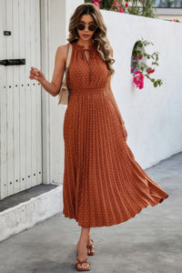 Woman wearing Sleeveless Dot Print Cross Fit Pleated Dress-Step into effortless charm with this Sleeveless Dot Print Cross Fit Pleated Dress. Featuring a playful dot print paired with a flattering cross-fit bodice