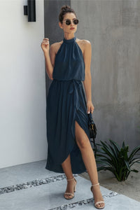 Woman wearing Halter Neck Empire Waist Spilt Dress-Turn heads with this Halter Empire Waist Split Dress. Designed with a flattering halter neckline, elegant empire waist, and a stylish front split for added drama.
