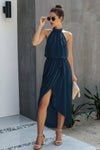 Woman wearing Halter Neck Empire Waist Spilt Dress-Turn heads with this Halter Empire Waist Split Dress. Designed with a flattering halter neckline, elegant empire waist, and a stylish front split for added drama.