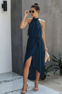 Woman wearing Halter Neck Empire Waist Spilt Dress-Turn heads with this Halter Empire Waist Split Dress. Designed with a flattering halter neckline, elegant empire waist, and a stylish front split for added drama.