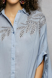 Sky blue 100% cotton POL button-down shirt with intricate leaf embroidery, voluminous draped sleeves, and a tailored collar.