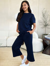 Textured, stretchy, and comfy. This two piece cropped pant with short sleeve top is a great travel set to stay comfortable in the car or plane. Available in a variety of colors and extended sizes.