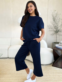 Textured, stretchy, and comfy. This two piece cropped pant with short sleeve top is a great travel set to stay comfortable in the car or plane. Available in a variety of colors and extended sizes.