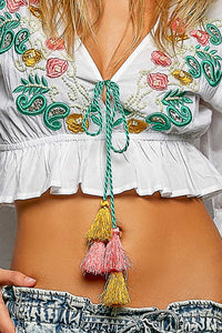 Boho Floral Embroidered Cropped V Neck Blouse with braided tie, tassels, and ruffled hem.