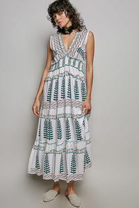 Ivory V-neck sleeveless tiered dress with leafy floral print, smocked waistband, and ruffle accents.