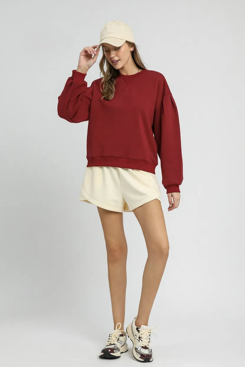 Burgundy Sweatshirt with Pleated Detail-Cozy meets chic in this burgundy pleated sweatshirt. A fall-ready round neck pullover with soft sleeve details, perfect for layering or lounging. Sizes XS–L.-Reef Love Boutique