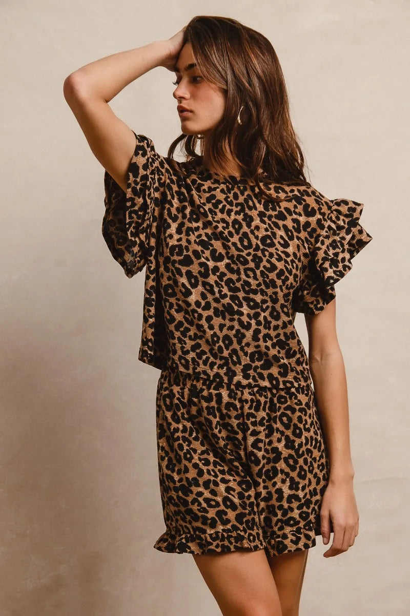 Woman wearing Leopard Print Waffle Texture Layered Ruffle Sleeve Top and Shorts Set-This leopard print set features a leopard print waffle texture top with layered ruffle sleeves, paired with matching shorts for a coordinated and stylish look. 