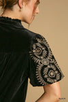Woman wearing Velvet Embroidered Sleeve Blouse-This velvet embroidered sleeve blouse combines luxe velvet with embroidery for a sophisticated and stylish look. Perfect for adding a touch of glamour to your outfit.