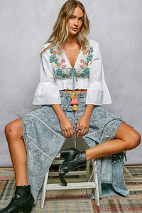 White cotton Boho Floral Embroidered Cropped V Neck Blouse with braided tie, tassels, and flared ruffle sleeves.
