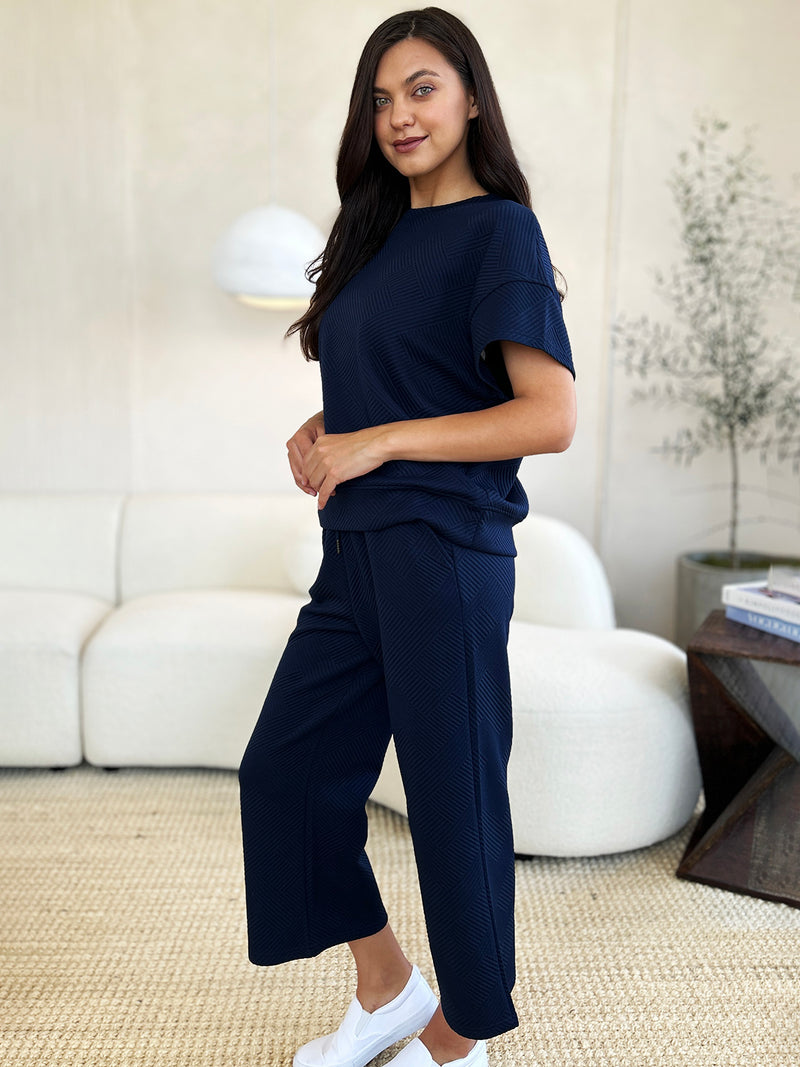 Textured, stretchy, and comfy. This two piece cropped pant with short sleeve top is a great travel set to stay comfortable in the car or plane. Available in a variety of colors and extended sizes.