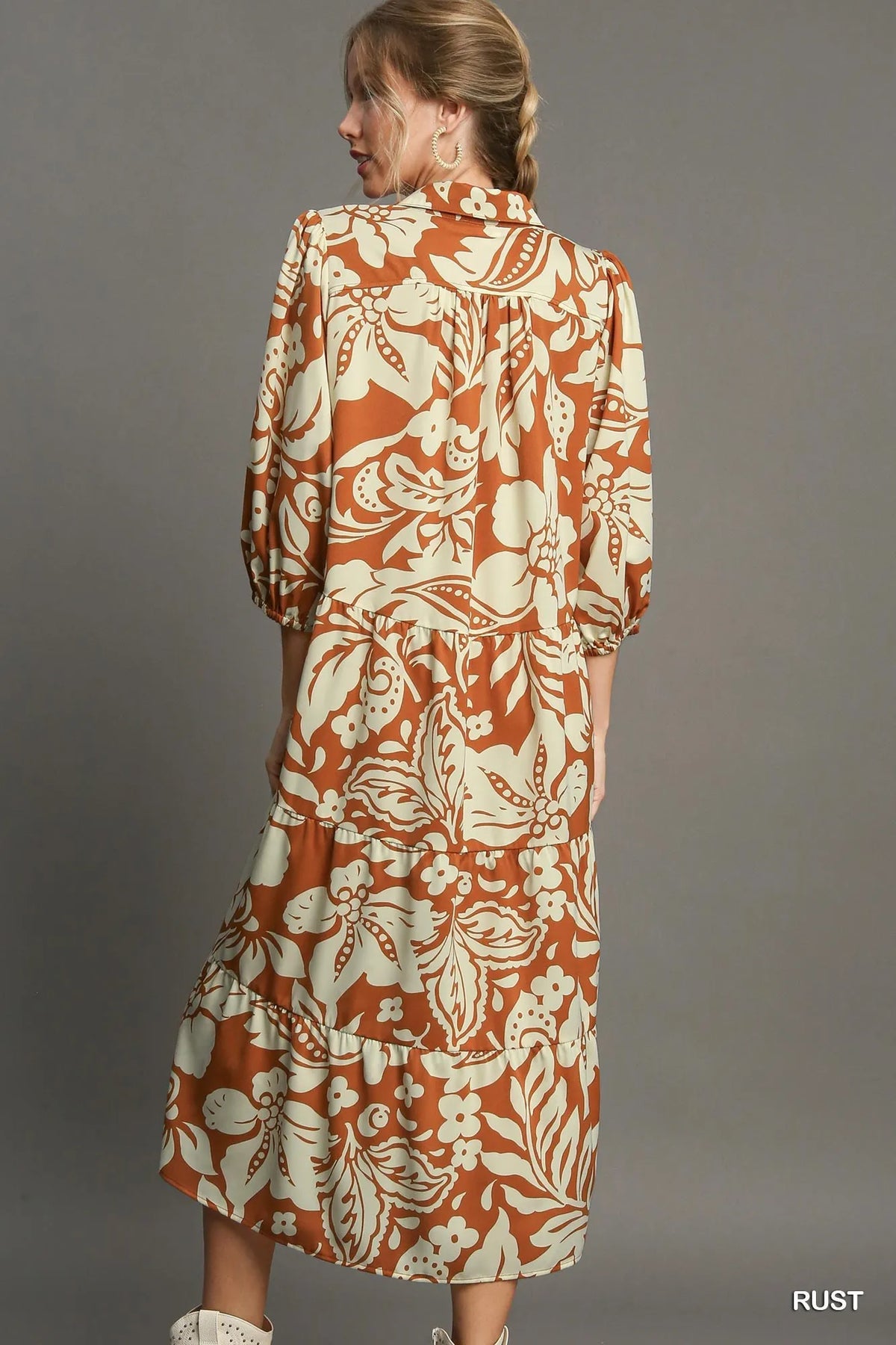 Woman wearing Floral Tiered Midi Shirt Dress-Flowy floral tiered midi shirt dress with 3/4 sleeves in rust + beige print. Boho-chic style in standard & plus sizes for casual or dressy days.