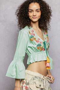 Mint Boho Floral Embroidered Cropped Blouse with V-neck, braided tassel tie, and flared ruffle sleeves.