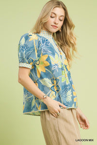 Vibrant blue floral print puff sleeve blouse with high neckline, perfect for warm weather.