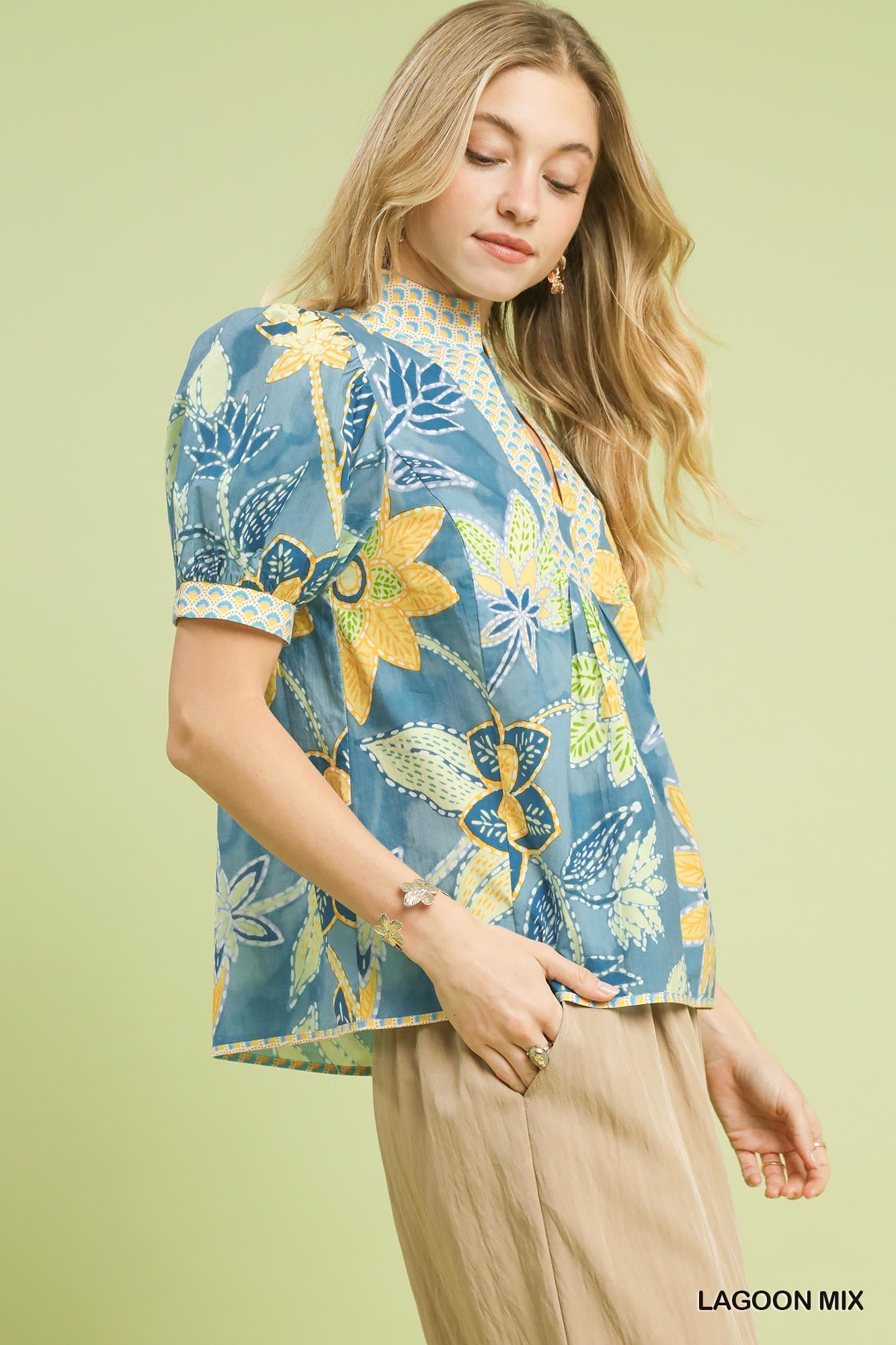 Vibrant blue floral print puff sleeve blouse with high neckline, perfect for warm weather.