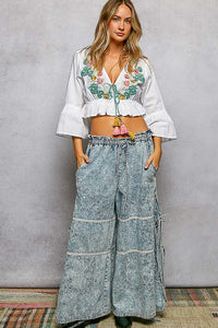 White Boho Floral Embroidered Cropped V Neck Blouse with braided tie, tassels, and flared ruffle sleeves.