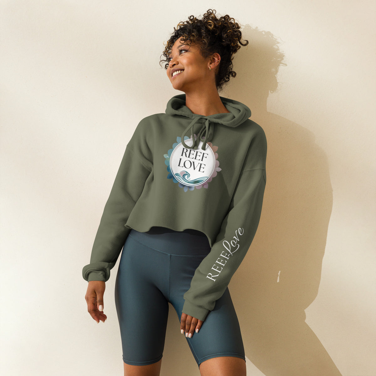 Woman wearing a green hoodie with 'Reef Love' logo and text on a beige background